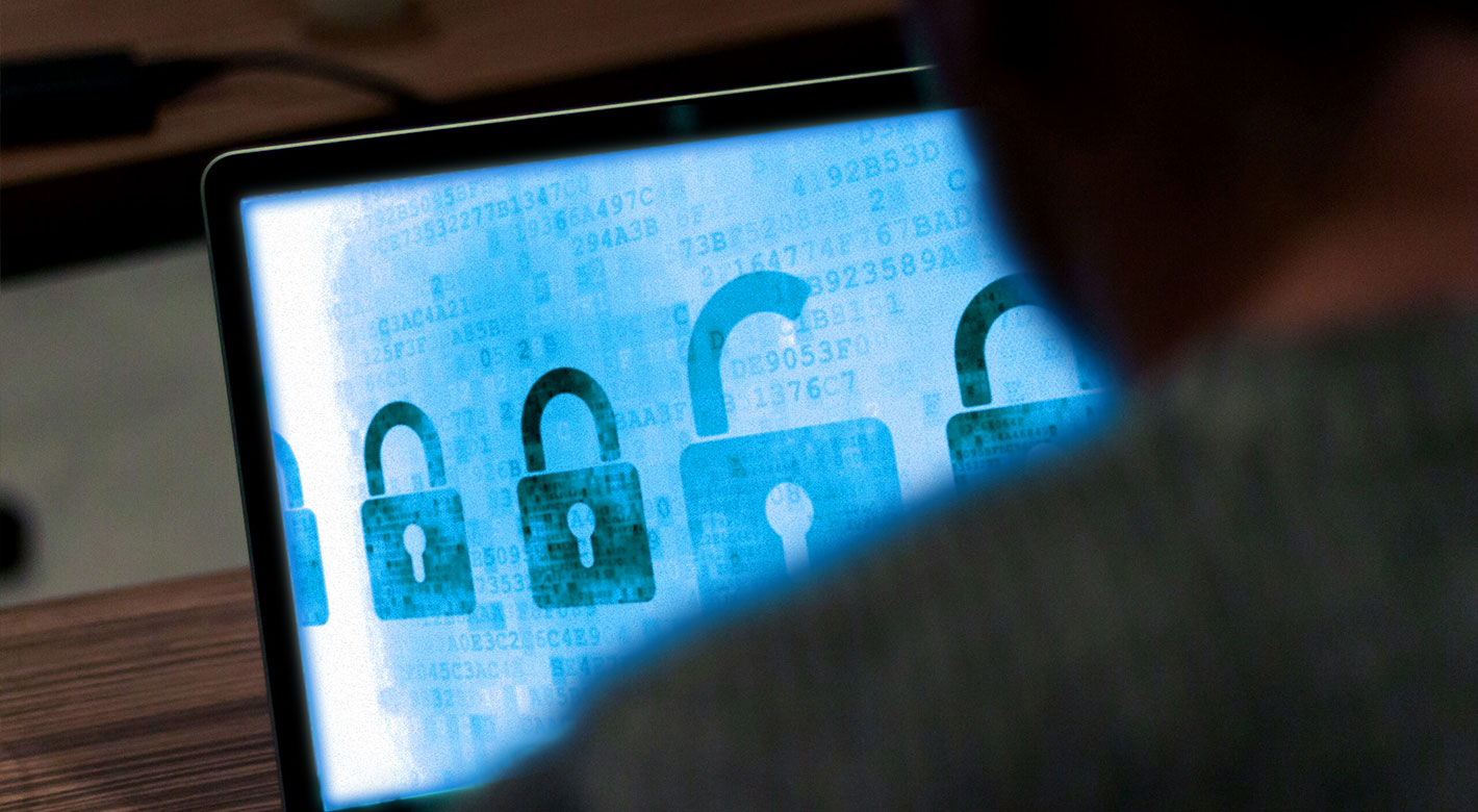 Person reviewing a laptop screen displaying digital security locks, symbolizing cybersecurity monitoring and threat detection.